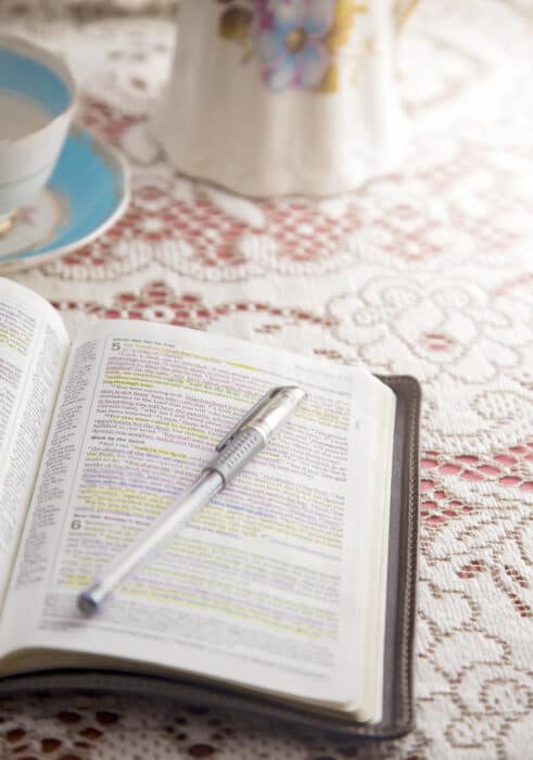 bible and coffee on pink and white tablecloth
